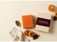 Vensoll soap bar and box styled with fresh persimmons and linen